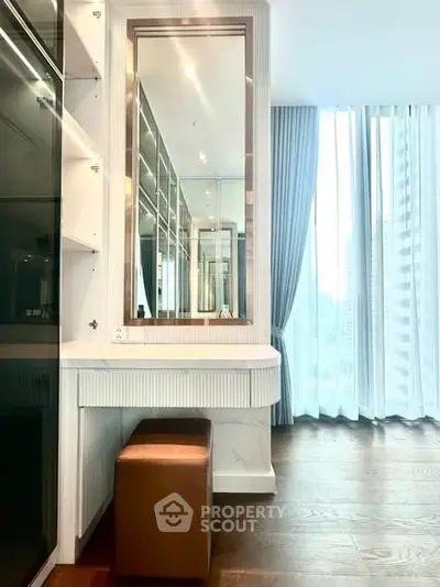 Modern bedroom with elegant vanity and floor-to-ceiling windows in a luxury apartment.