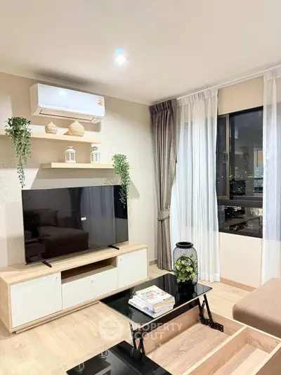 Modern living room with large TV, stylish decor, and city view through window.