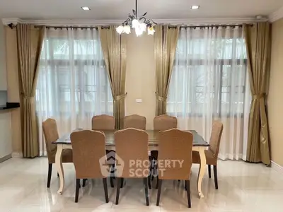 Elegant dining room with large table and stylish chairs, featuring natural light and modern decor.