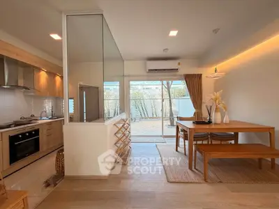 Modern open-plan kitchen and dining area with natural light and stylish decor.