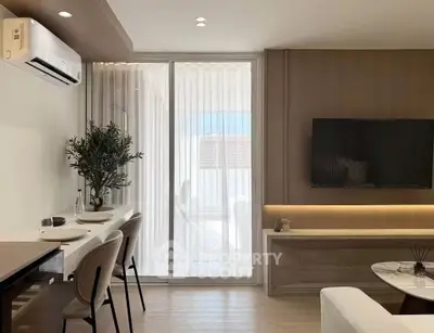 Modern living room with sleek design, featuring a wall-mounted TV and elegant dining area.