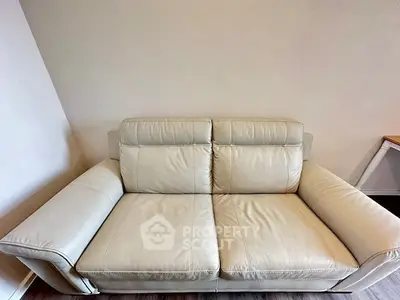 Modern beige leather sofa in a stylish living room setting.
