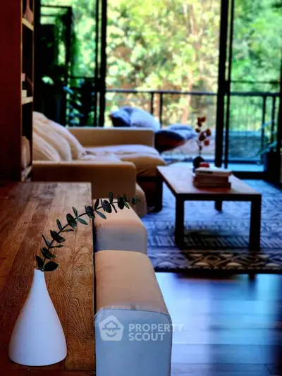 Spacious living room with cozy seating and lush garden view, perfect for relaxation.