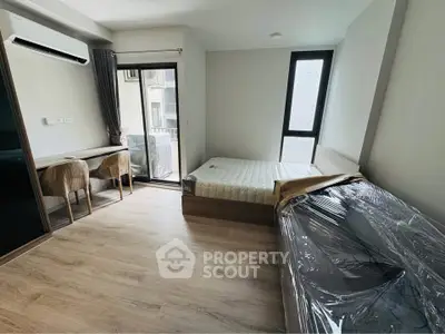 Modern bedroom with balcony access and stylish furnishings in a contemporary apartment.