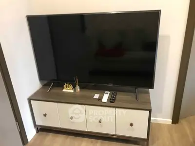 Modern living room with sleek TV stand and large flat-screen TV, perfect for entertainment.
