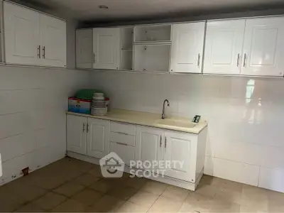 Spacious kitchen with white cabinets and ample counter space, perfect for culinary enthusiasts.