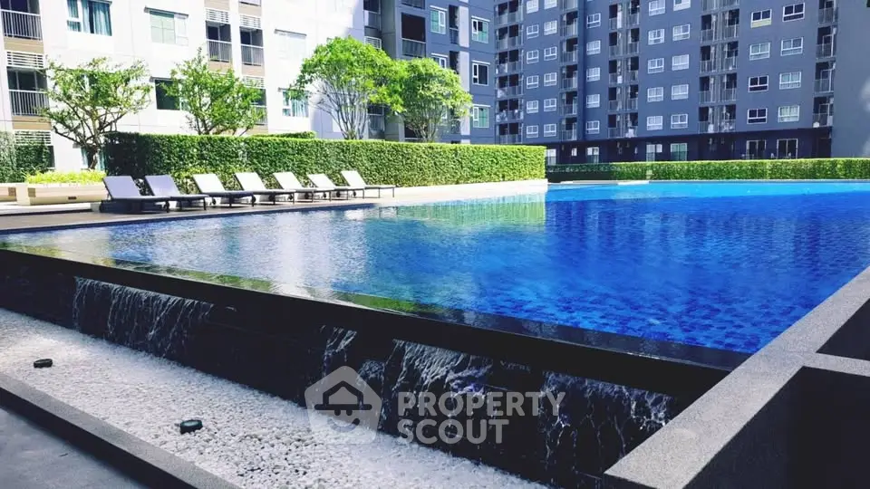 Luxurious condominium pool area with modern design and lush greenery.