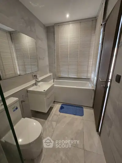 Modern bathroom with sleek fixtures and bathtub, featuring elegant tile design.