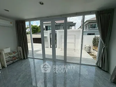 Spacious room with large glass doors opening to a private patio, perfect for natural light lovers.