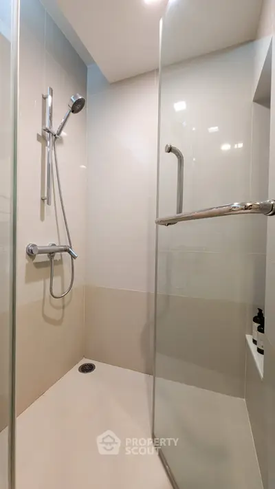 Modern bathroom with sleek glass shower enclosure and chrome fixtures