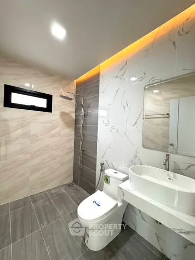 Modern bathroom with sleek design, featuring a walk-in shower and elegant fixtures.
