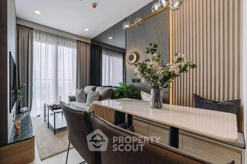 Modern living room with elegant decor and natural light, featuring a stylish dining area and cozy seating.