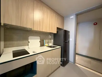 Modern kitchen with sleek cabinetry and appliances in a compact layout.