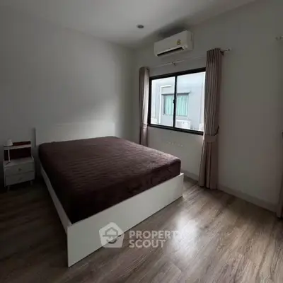 Spacious bedroom with modern design and large window for natural light.