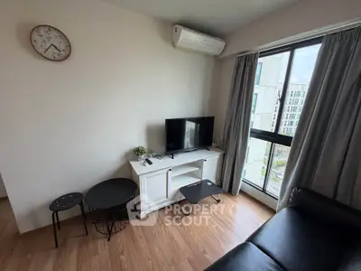 Cozy living room with modern decor, featuring a TV, air conditioning, and a large window with city view.