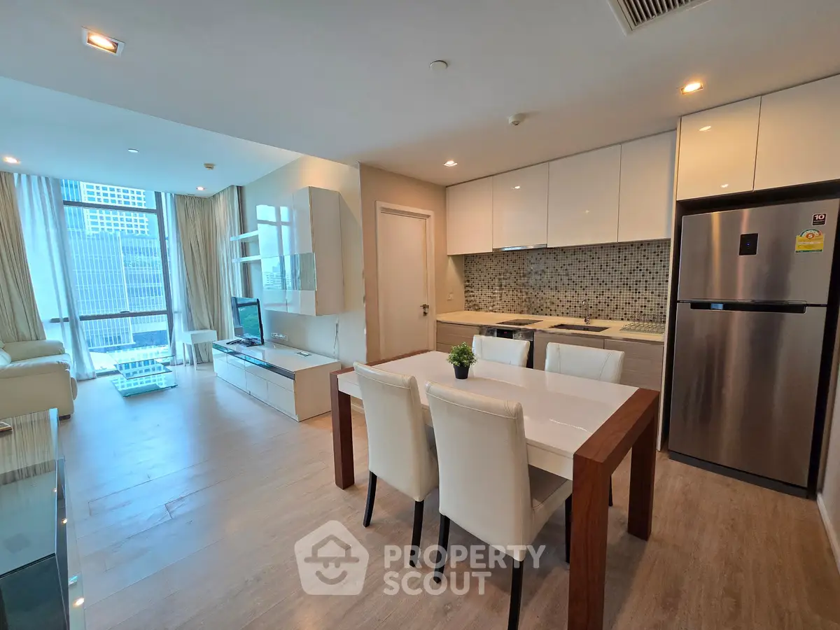 Modern open-plan living room and kitchen with sleek design and city view.