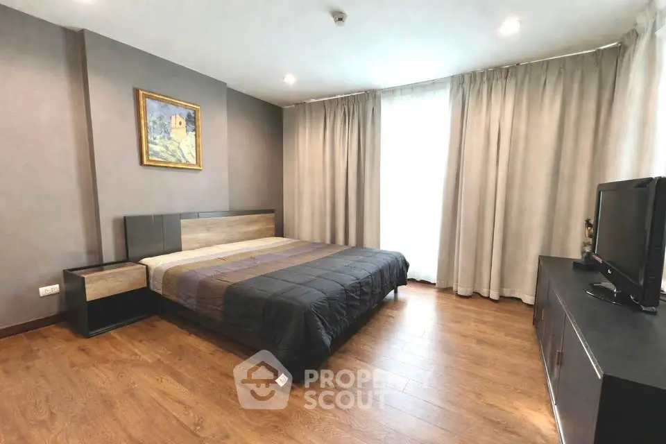 Spacious modern bedroom with wooden flooring and stylish decor