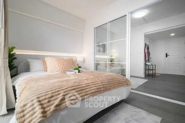 Modern bedroom with sliding glass closet doors and stylish decor