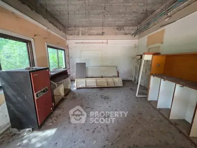 Spacious fixer-upper room with large windows and potential for renovation.