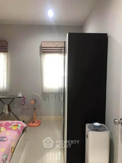 Cozy bedroom with modern wardrobe and air purifier, perfect for a comfortable living space.