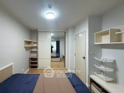 Modern bedroom with mirrored wardrobe and stylish shelving in a cozy apartment.