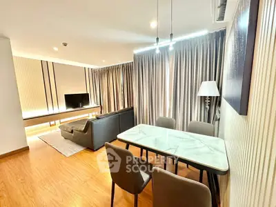 Modern living room with dining area, featuring stylish furniture and elegant lighting.