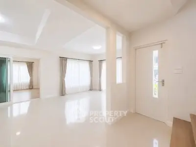 Spacious and bright living area with large windows and elegant curtains in modern home.