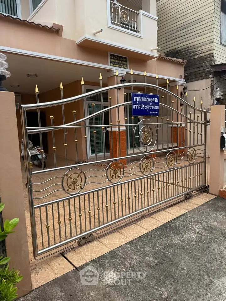 Elegant gated entrance of a modern townhouse with decorative metalwork.