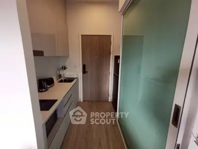 Modern compact kitchen with sleek cabinetry and sliding glass door