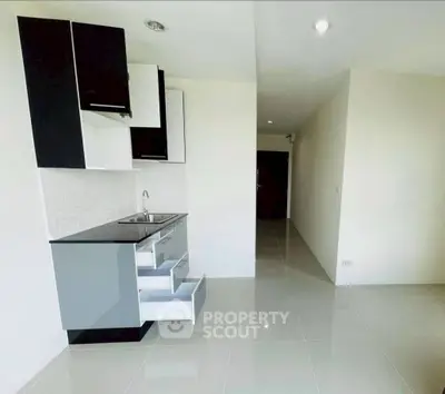 Modern minimalist kitchen with sleek cabinetry and glossy tile flooring.