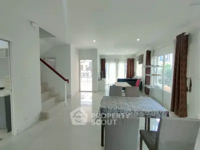 Spacious modern living room with dining area and staircase in bright open layout