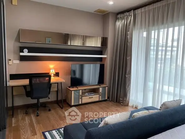 Modern living room with sleek furniture and large window offering natural light.
