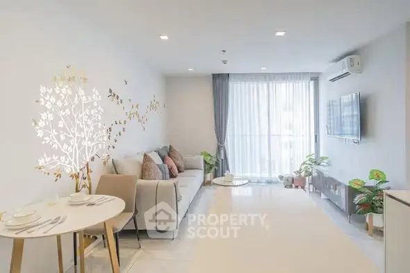 Modern living room with stylish decor and natural light, featuring a cozy sofa and elegant dining area.