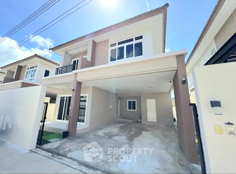 Modern two-story house with spacious driveway and contemporary design under a clear blue sky.