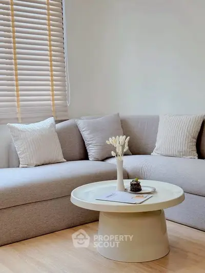 Modern living room with stylish sofa and round coffee table, perfect for relaxation.