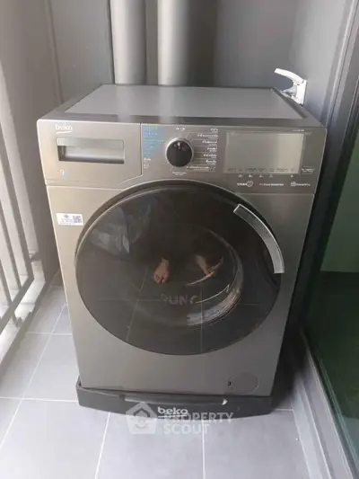 Modern washing machine on a balcony in a contemporary apartment setting.