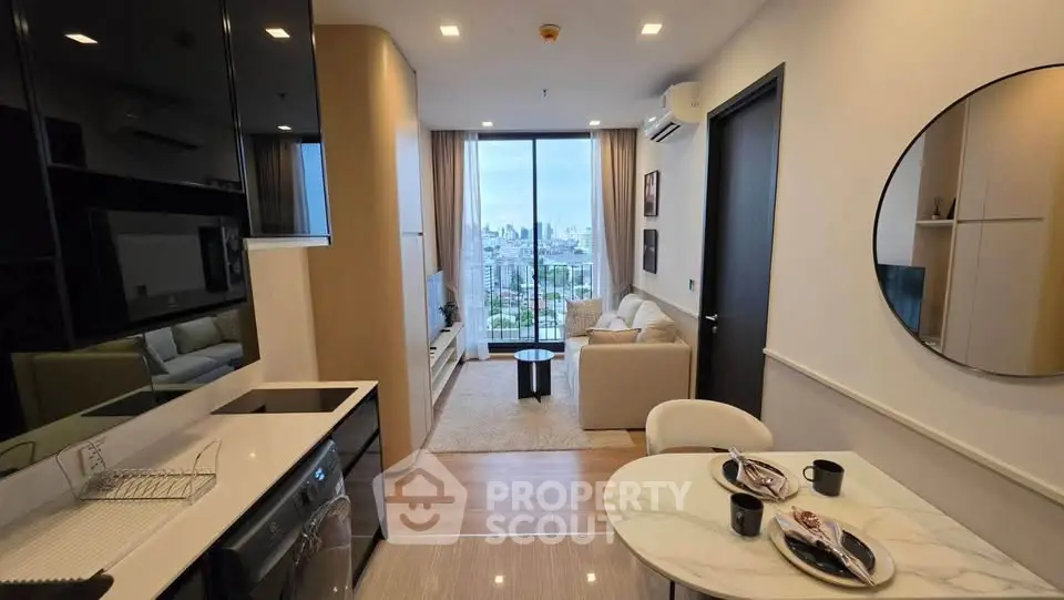 Modern open-layout living room with city view, stylish decor, and sleek kitchen area.