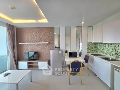 Modern open-layout living room and kitchen with stylish decor and appliances.