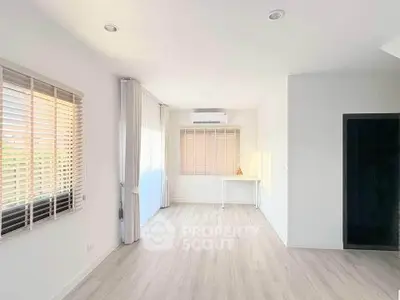 Bright and spacious room with large windows and modern flooring, perfect for versatile living space.
