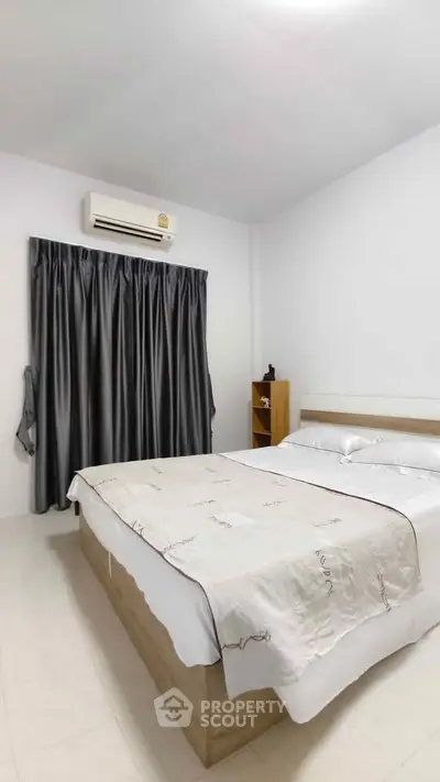 Cozy bedroom with air conditioning and elegant curtains, perfect for relaxation.