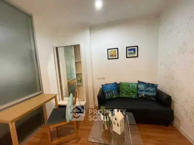 Cozy living room with modern decor and wooden flooring, featuring a stylish sofa and elegant wall art.