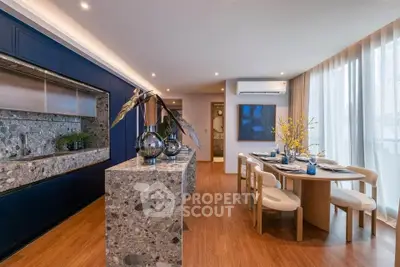 Luxurious open-plan kitchen and dining area with modern decor and elegant lighting.
