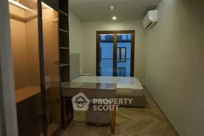Modern bedroom with sleek design, featuring a bed, desk, and air conditioning in a cozy apartment.