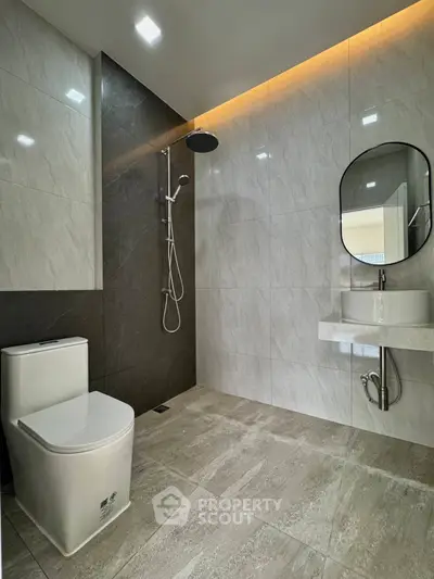 Modern bathroom with sleek design, featuring a walk-in shower and elegant fixtures.