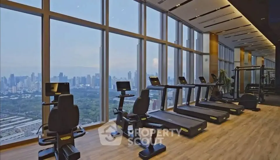 Luxurious high-rise gym with panoramic city views and modern fitness equipment.