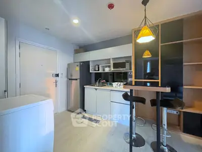 Modern kitchen with sleek appliances and stylish bar seating in a cozy apartment.