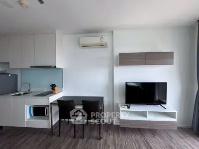 Modern living room with sleek kitchen and stylish furniture in a contemporary apartment.