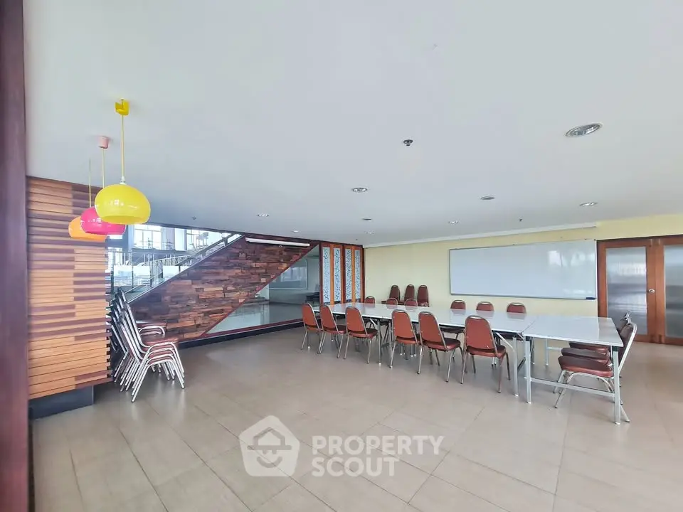 Spacious modern conference room with stylish lighting and ample seating in a contemporary building.