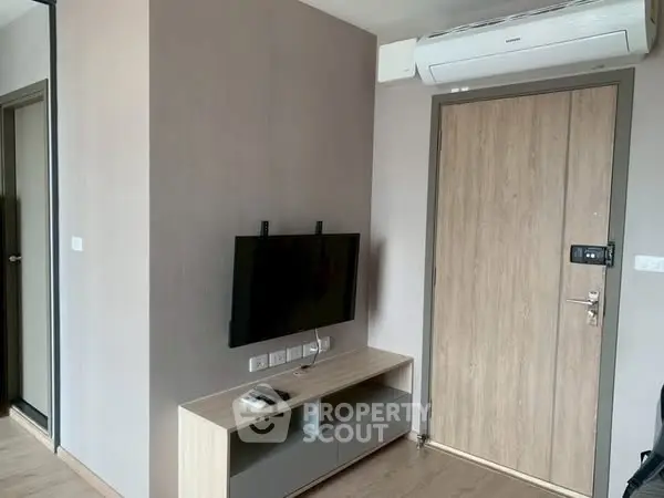 Modern apartment interior with wall-mounted TV and air conditioning unit.