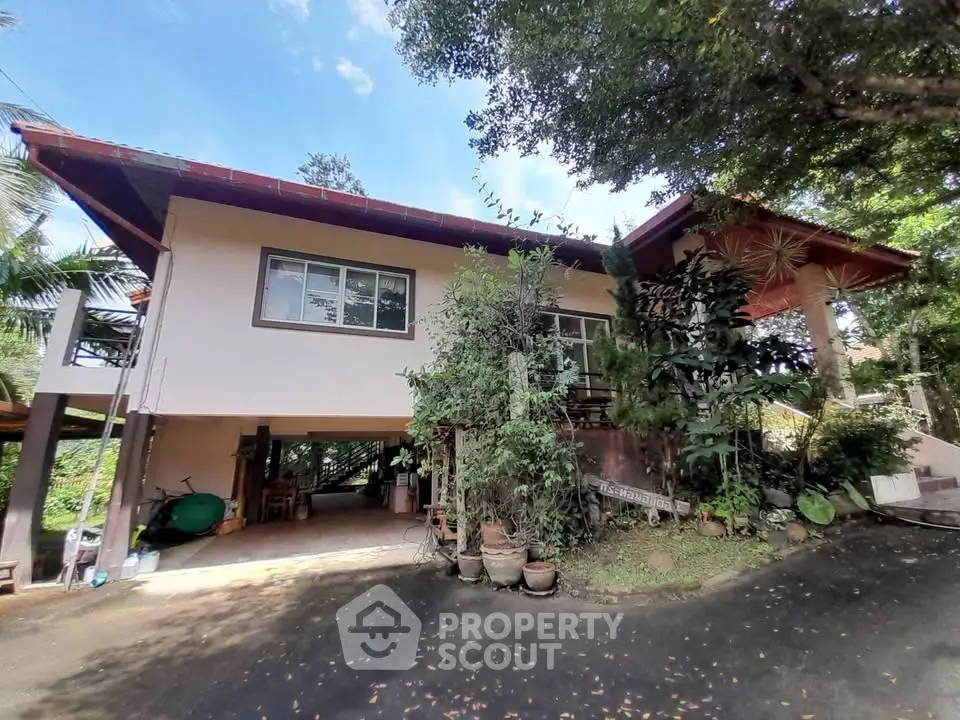 Charming two-story house with lush greenery and spacious driveway